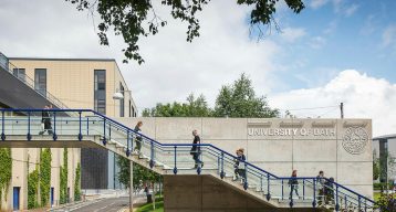 Exterior photograph of the University of Bath, with students climbing and descending a set of stairs across the frame