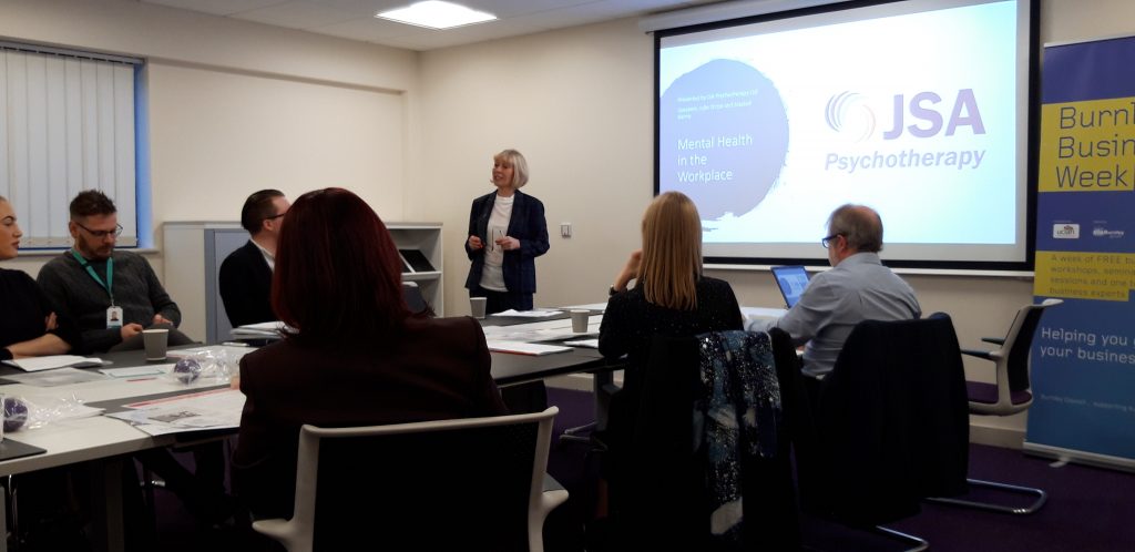 Photograph of Julie Stirpe delivering a presentation to the room